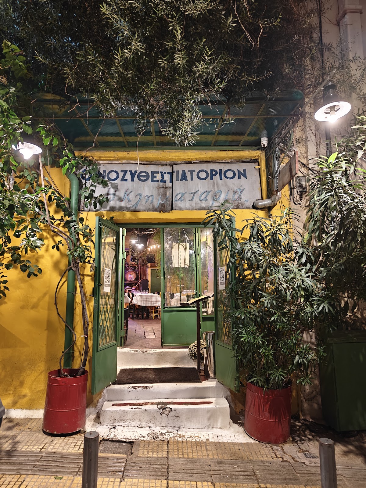 Warmly lit traditional taverna table with wine and meze in central Athens