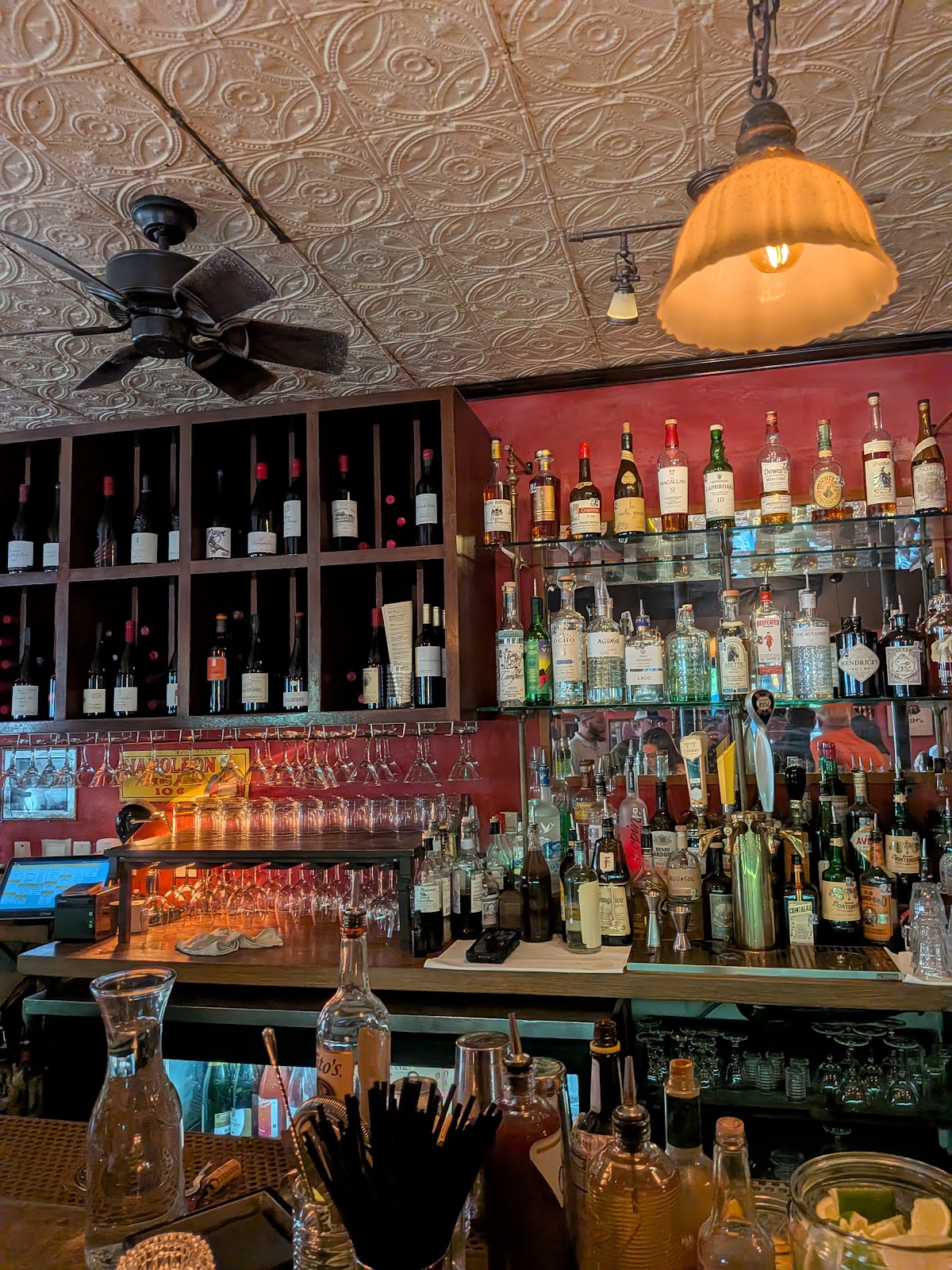 A low-lit bar with a French wine and spirits shelf at Justine's Brasserie in East Austin
