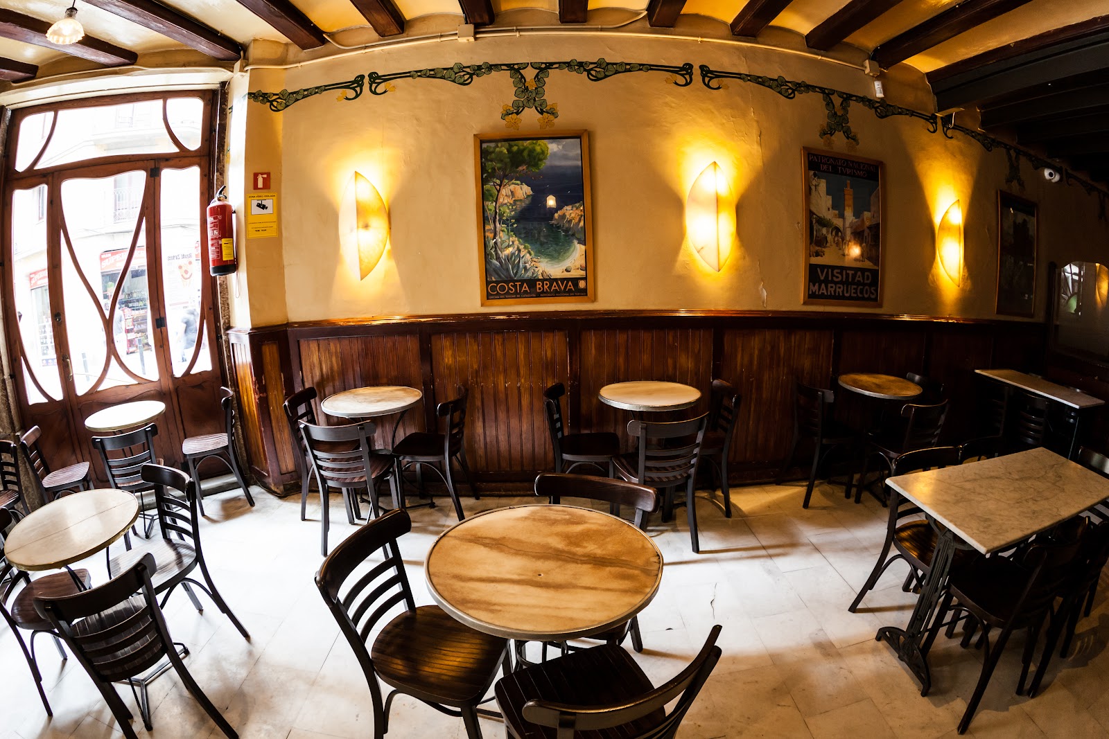 Historic marble-counter cocktail bar with carved wood and old mirrors in El Raval Barcelona