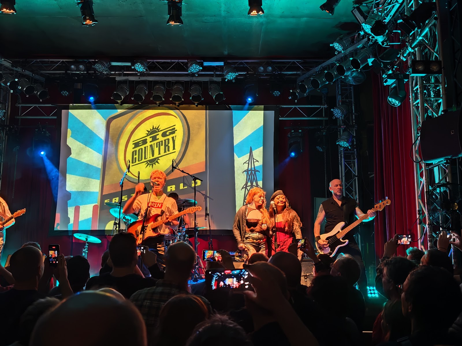 Live band on a club stage with a standing crowd, in the style of Lido in Kreuzberg Berlin