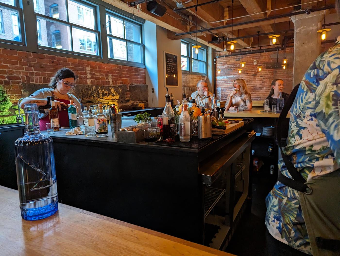 Craft cocktail being prepared at a bar with fresh ingredients
