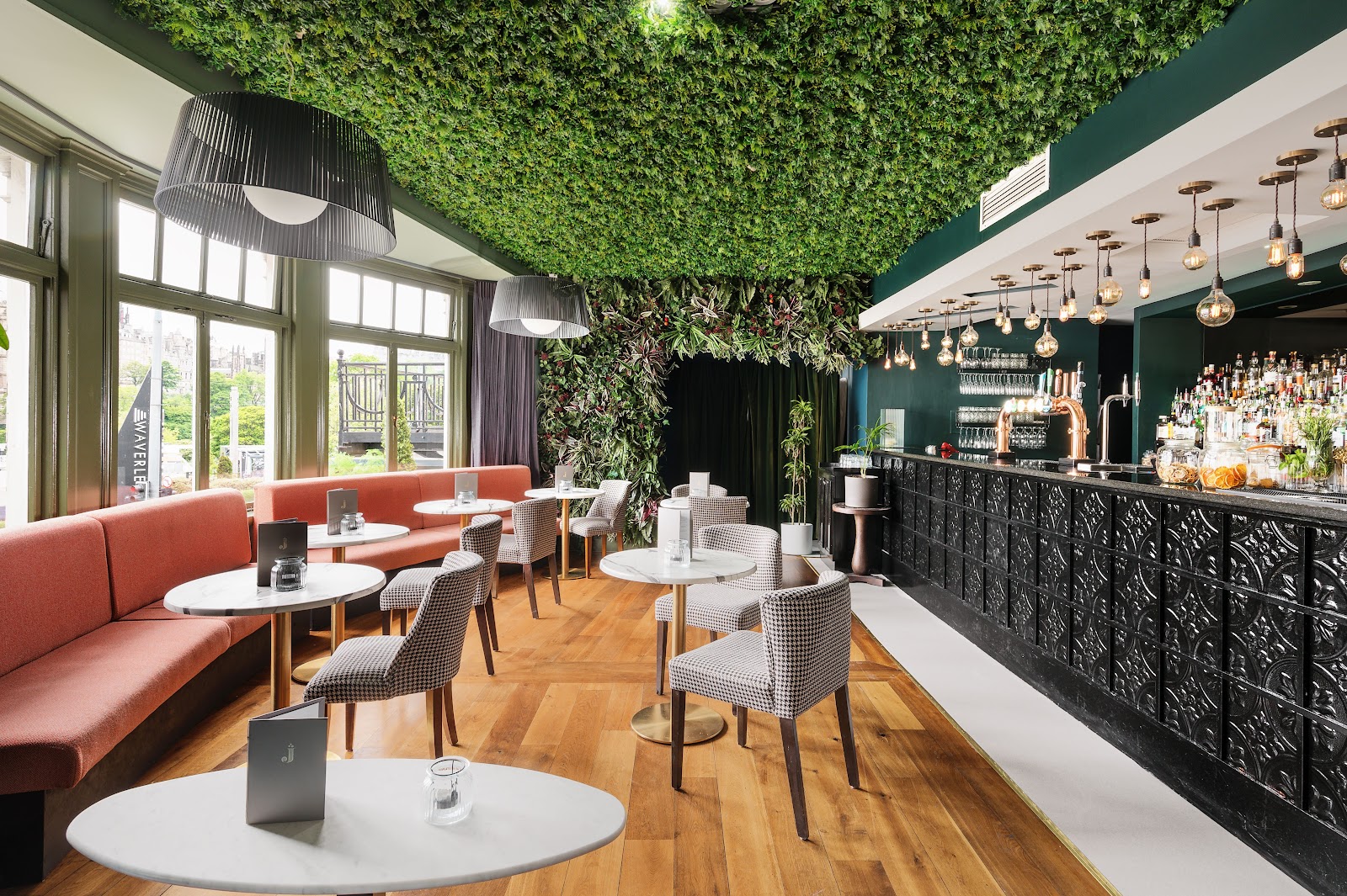 Rooftop cocktail bar with full-frontage windows over Princes Street at Juniper Edinburgh