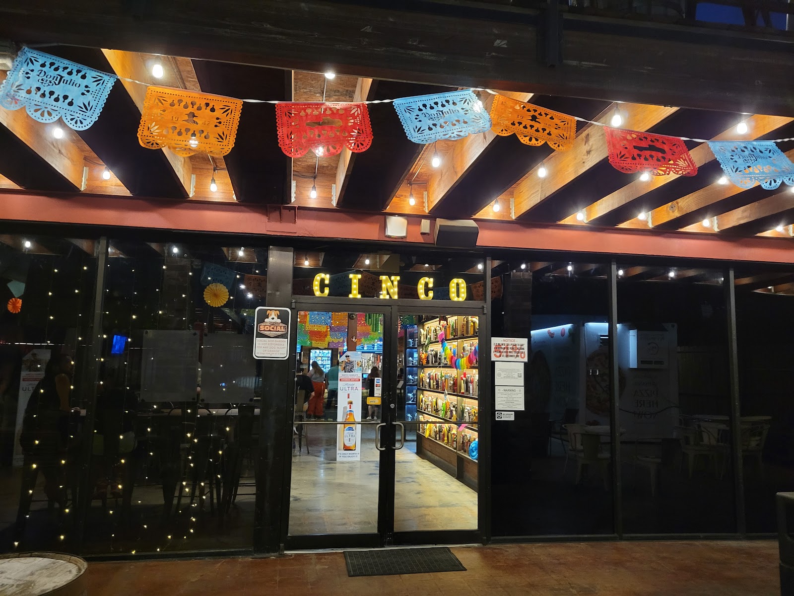 Outdoor beer garden with string lights and a large screen in Midtown Houston