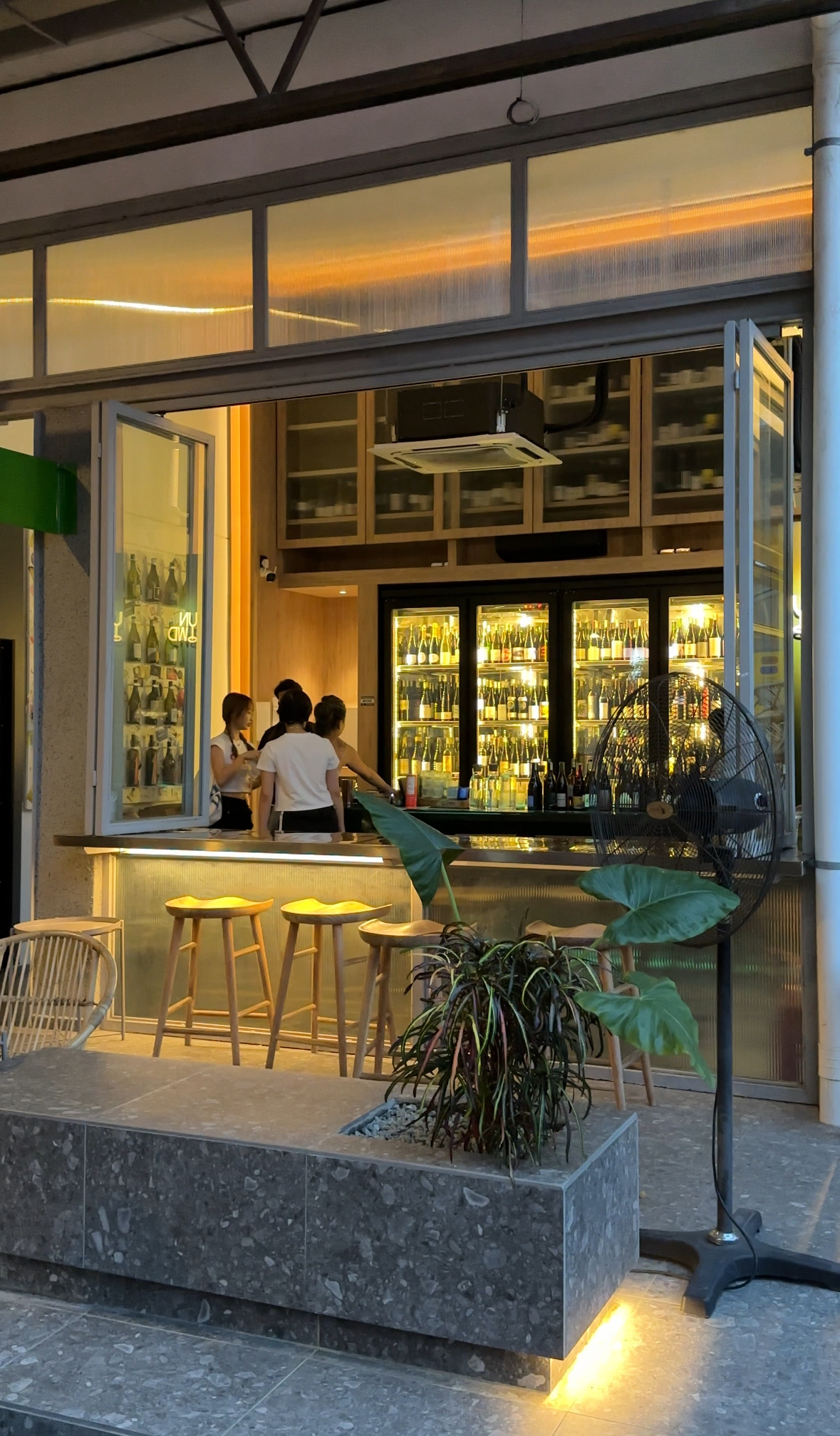 Warm low lit bar with bottles and soft light, similar in feel to Unwined Kuala Lumpur
