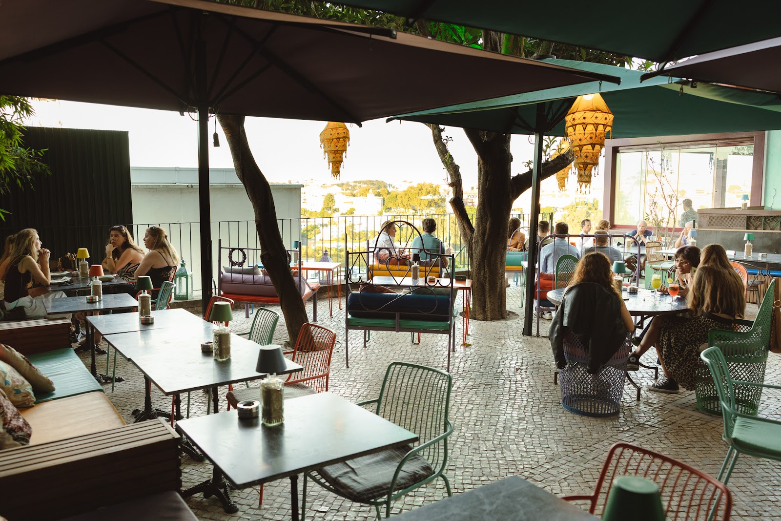 Garden terrace bar with cushions and panoramic rooftop views over Lisbon