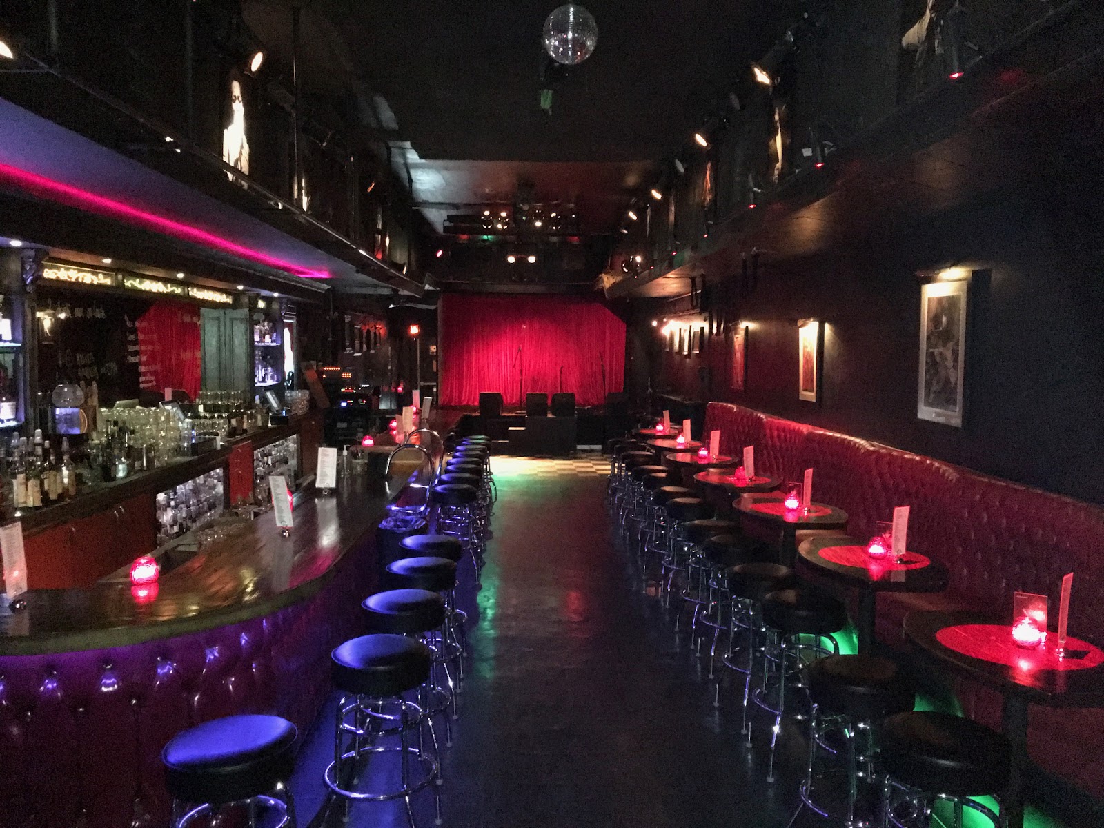 A dark, low-lit blues room with a stage, in the style of Harvelle's, Santa Monica