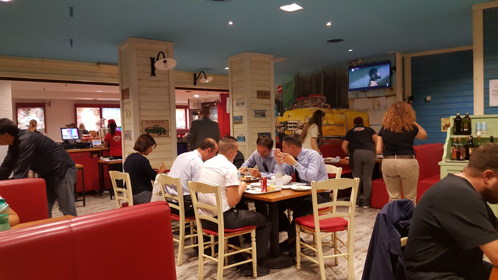 California-themed sports cafe interior with screens near Milan's Duomo
